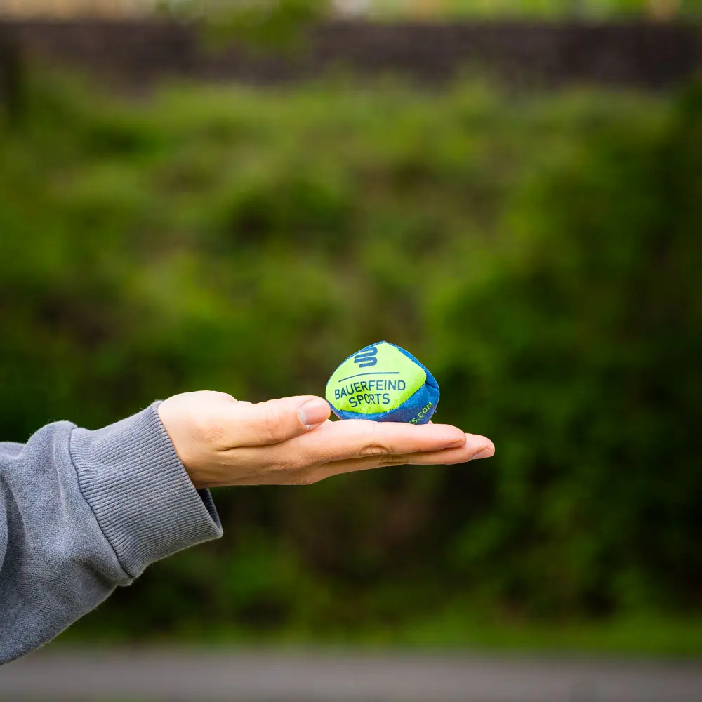 Hand, die einen kleinen Bauerfeind Sports Ball hält, ideal für Training und Koordination.