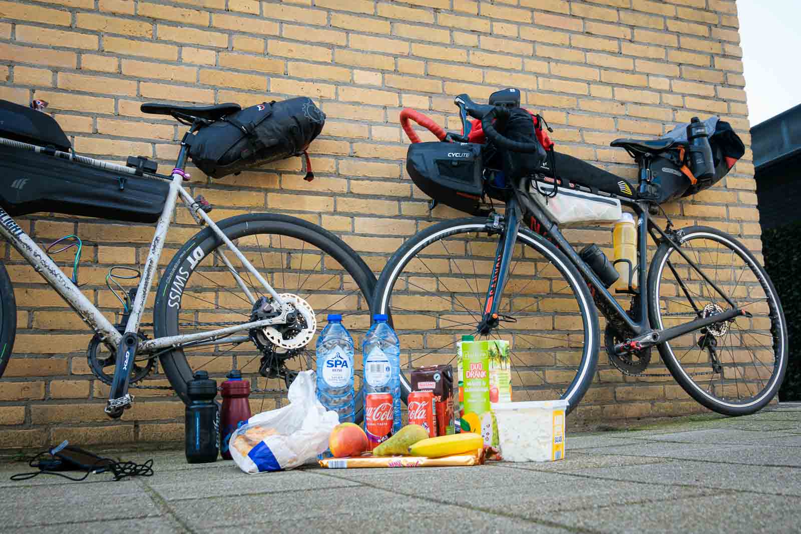 Auf dem Boden steht Proviant von zwei Teilnehmern des Race around the Netherlands, darunter Wasser, Kakao, Kartoffelsalat und Cola